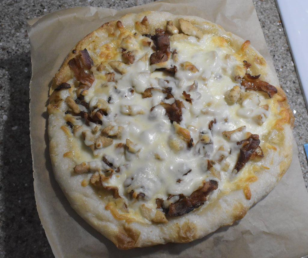 Small pizza on a piece of paper on a table