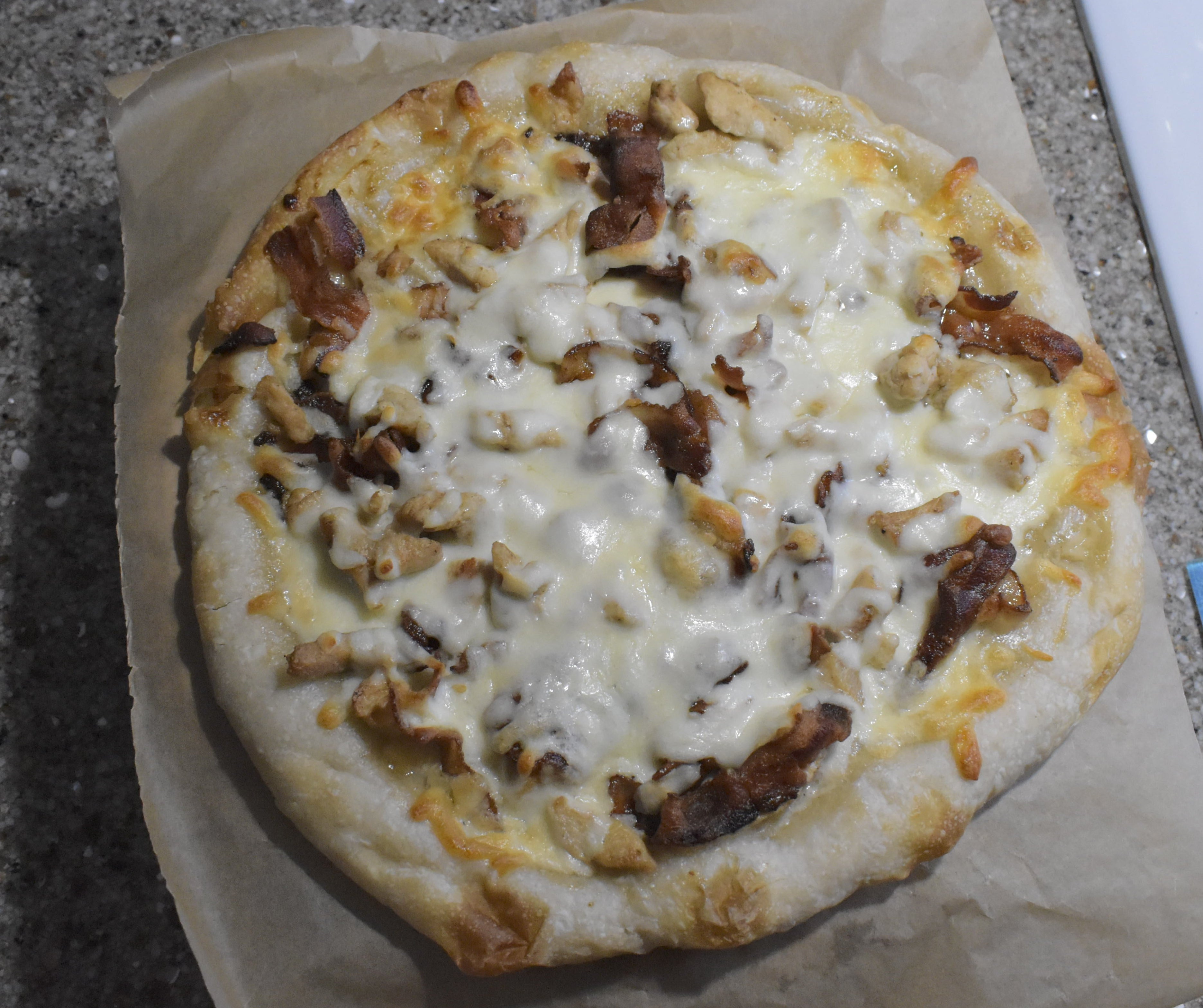 Small pizza on a piece of paper on a table